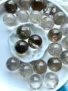 Overhead view of Smoky Quartz mini crystal spheres with glossy polish and natural color variation