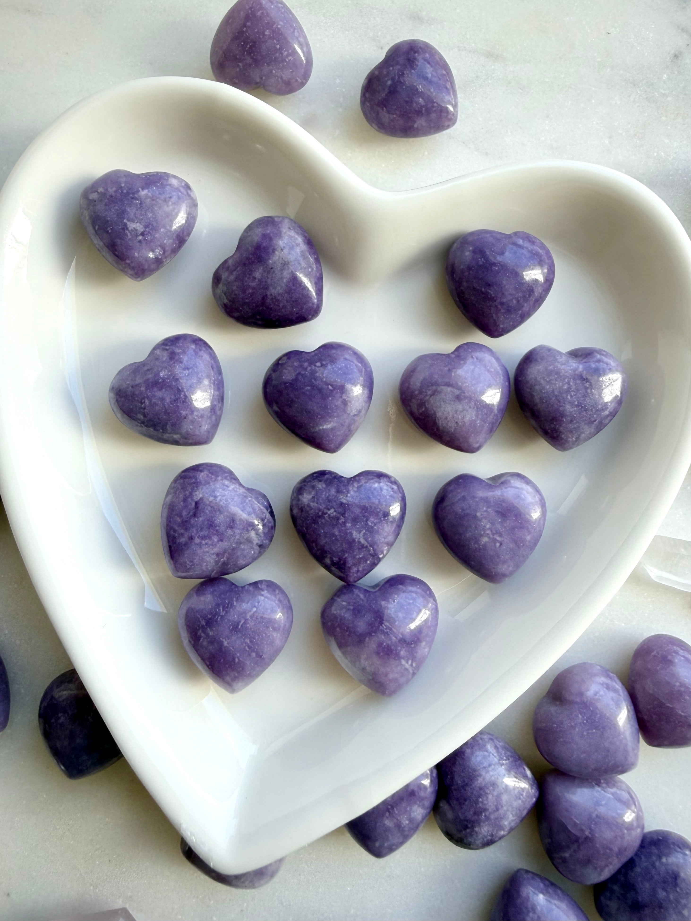 Lilac Lepidolite puffy hearts displayed in a white ceramic heart-shaped bowl