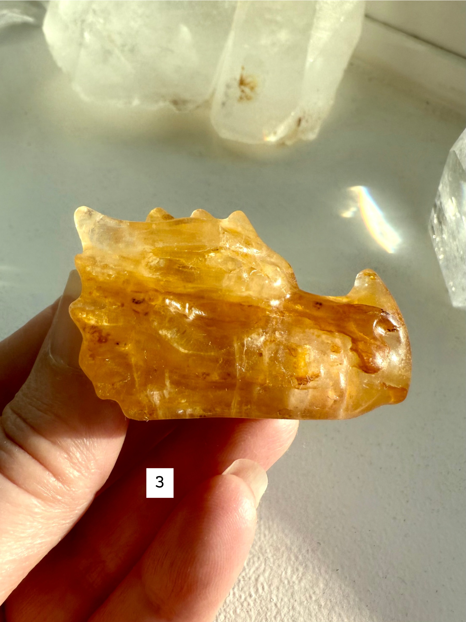 Small Golden Healer Quartz dragon head held in hand — crystal guardian carving for Solar Plexus healing, clarity, and spiritual connection.