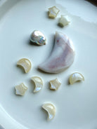 Mini Moonstone moons and stars displayed with an agate moon and baroque pearl on a ceramic tray