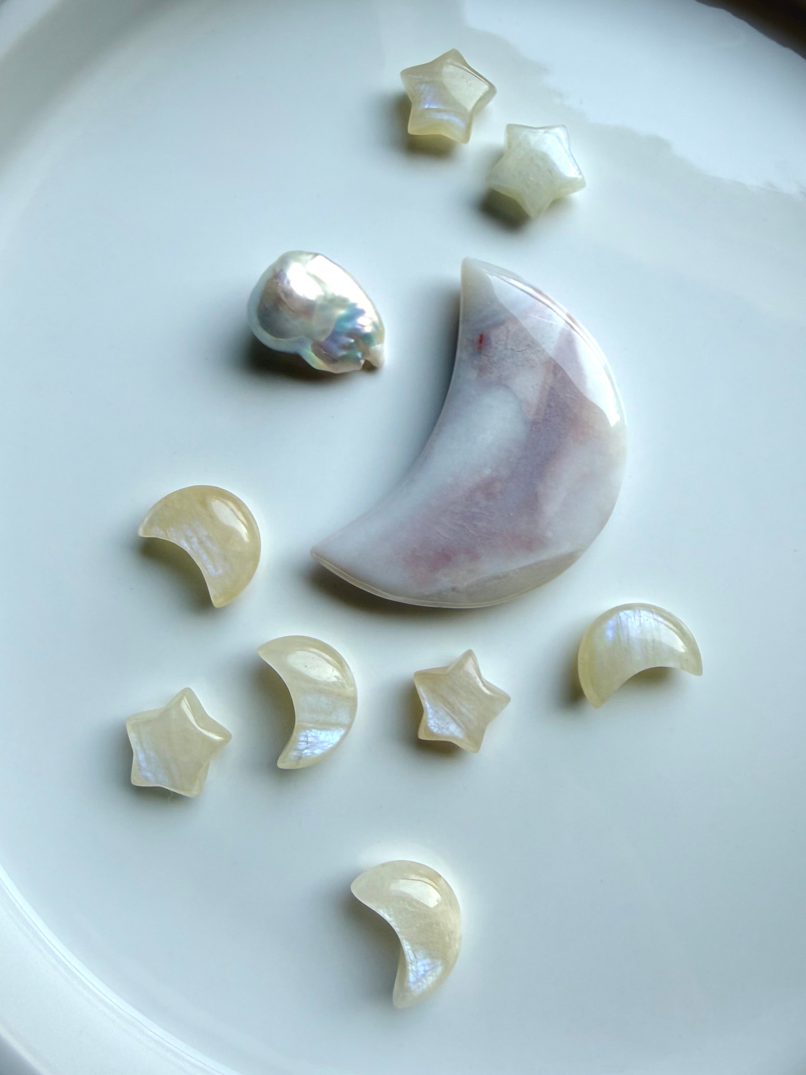 Mini Moonstone moons and stars displayed with an agate moon and baroque pearl on a ceramic tray