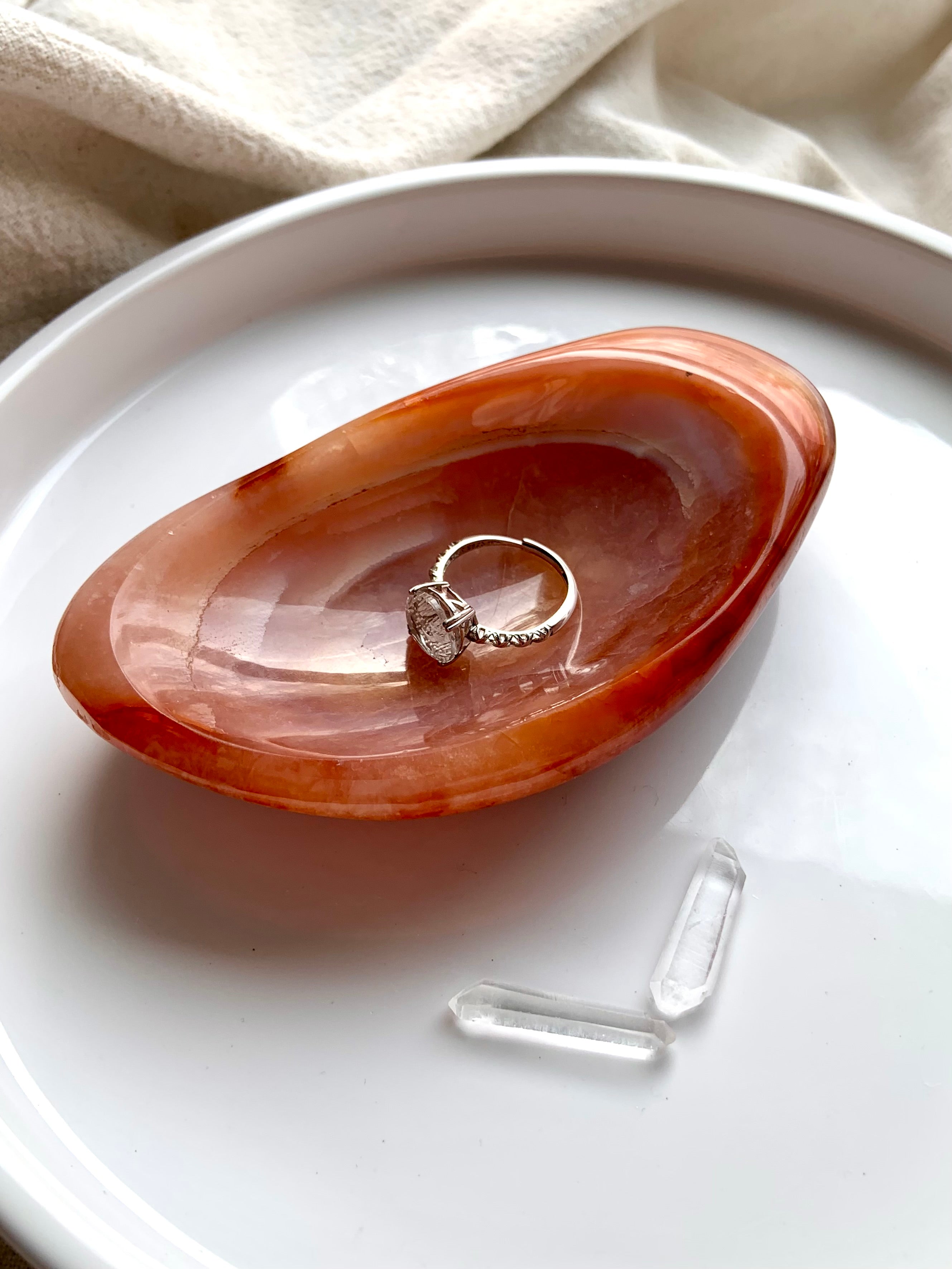 dainty moon ring displayed in orange carnelian crystal bowl with clear quartz points