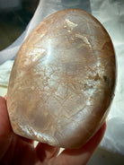 Rainbow Moonstone shimmer across a polished Peach Moonstone freeform with warm peach color and natural feldspar patterns