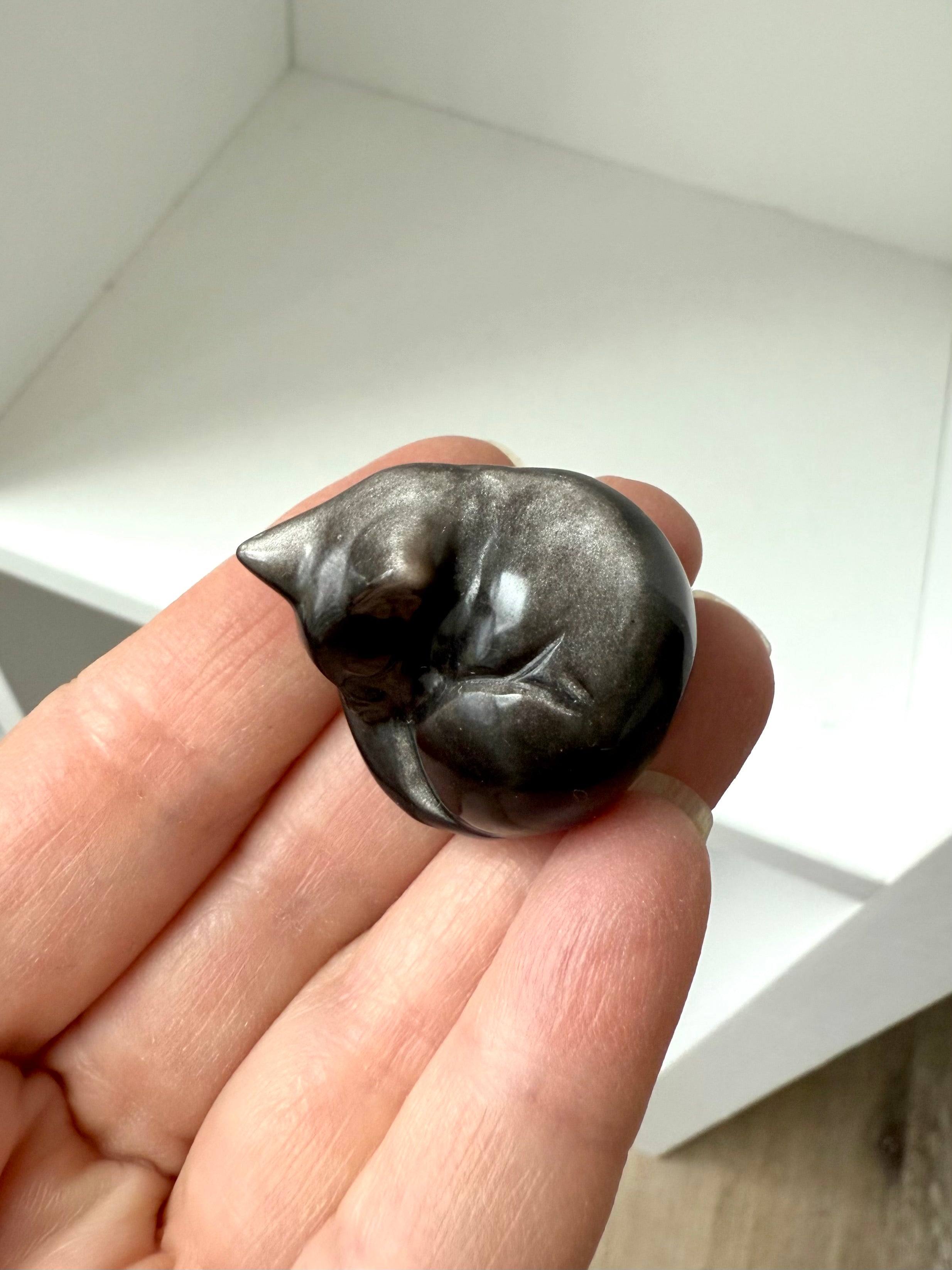 This tiny Silver Sheen Obsidian Sleeping Cat offers energetic protection to your sacred space. 