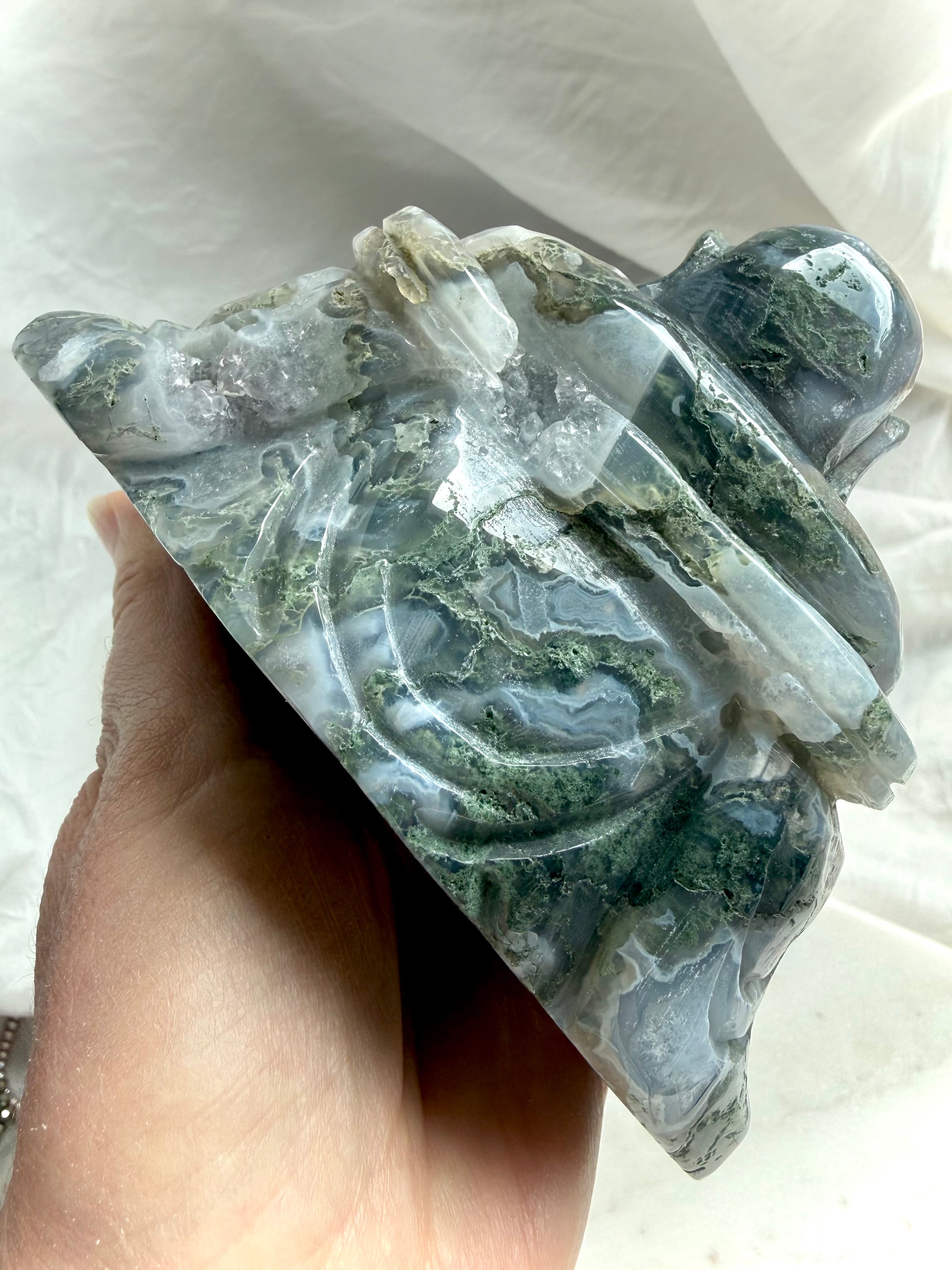 Back view of a Large Moss Agate Laughing Buddha statue showing scenic inclusions and carving detail