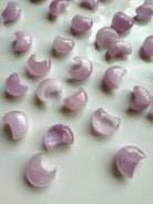 Mini Pink Kunzite crescent moons on a white plate — gentle pink crystal carvings for emotional healing & heart-centered energy work.