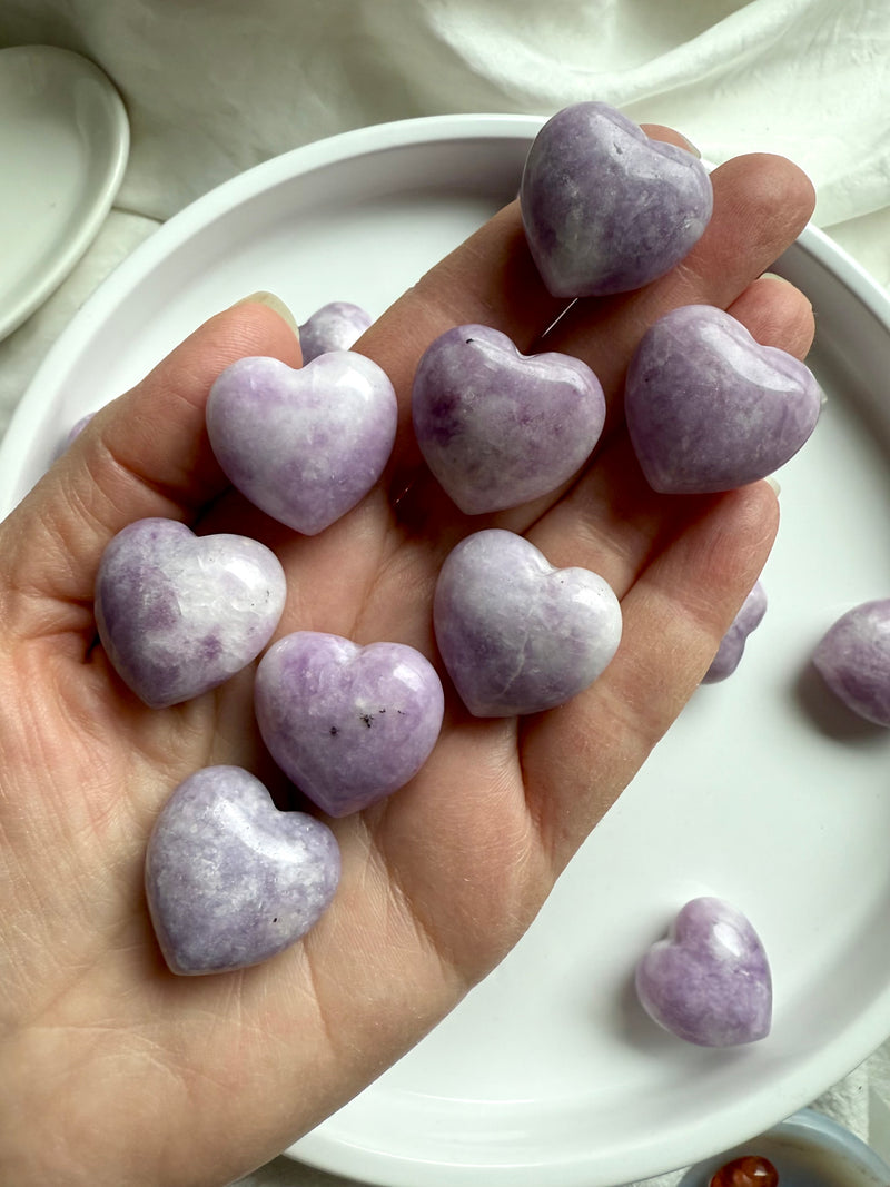 Calming lilac colored Lepidolite puffy hearts shown on my hand for scale