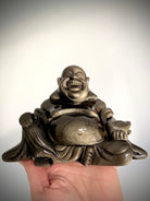 Close-up of laughing Buddha statue carved in Golden Sheen Obsidian, high-vibe crystal for manifestation and protection