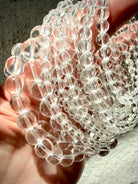 Clear Quartz bracelets arranged in a spiral showing multiple bead sizes and polished transparent crystal beads