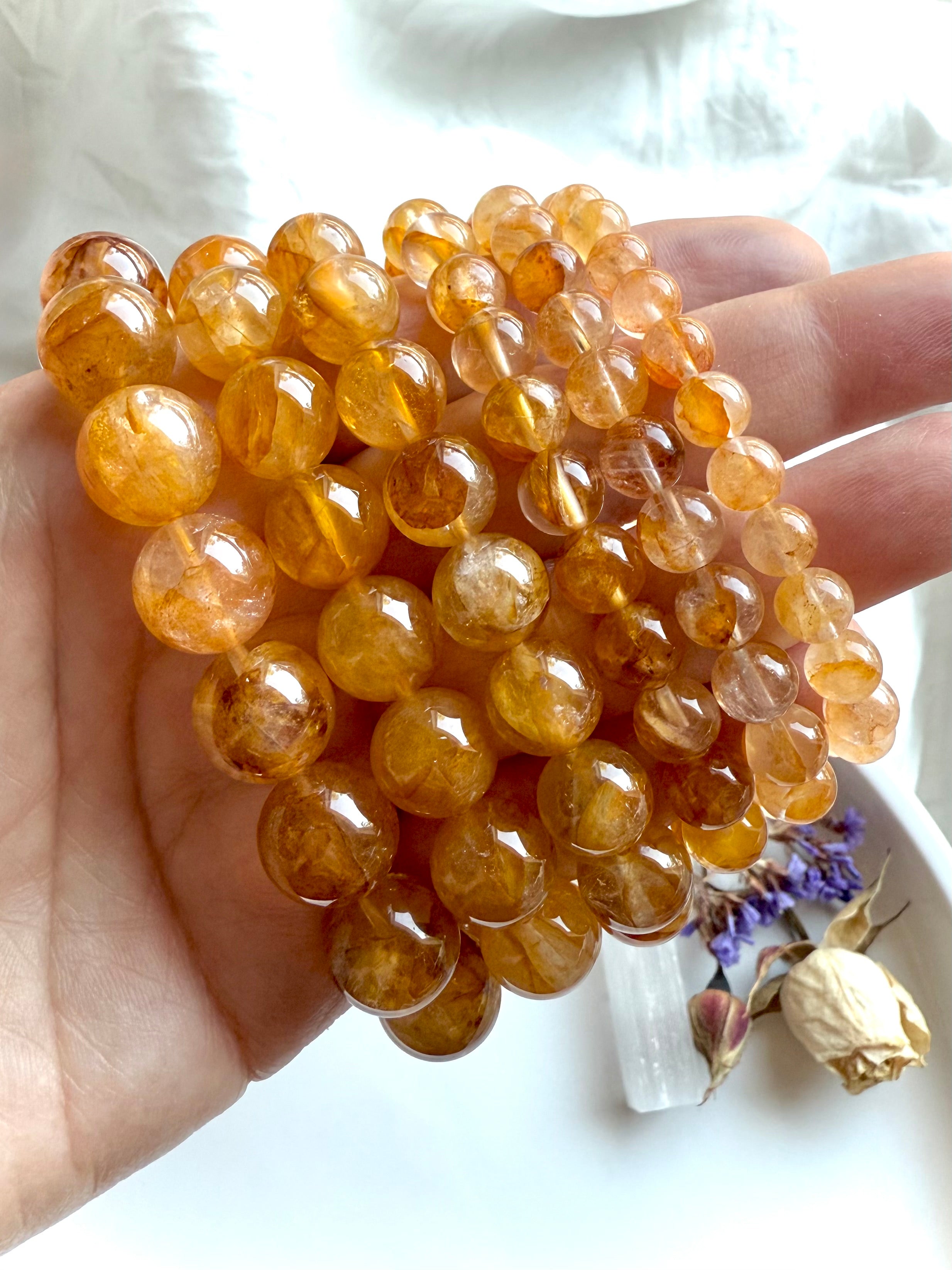 High-quality Golden Healer Quartz beads with rich golden inclusions and clear quartz transparency, gemstone jewelry detail.