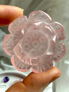 Hand-held Rose Quartz Lotus Flower crystal carving showing translucent pink detail and polished petal design