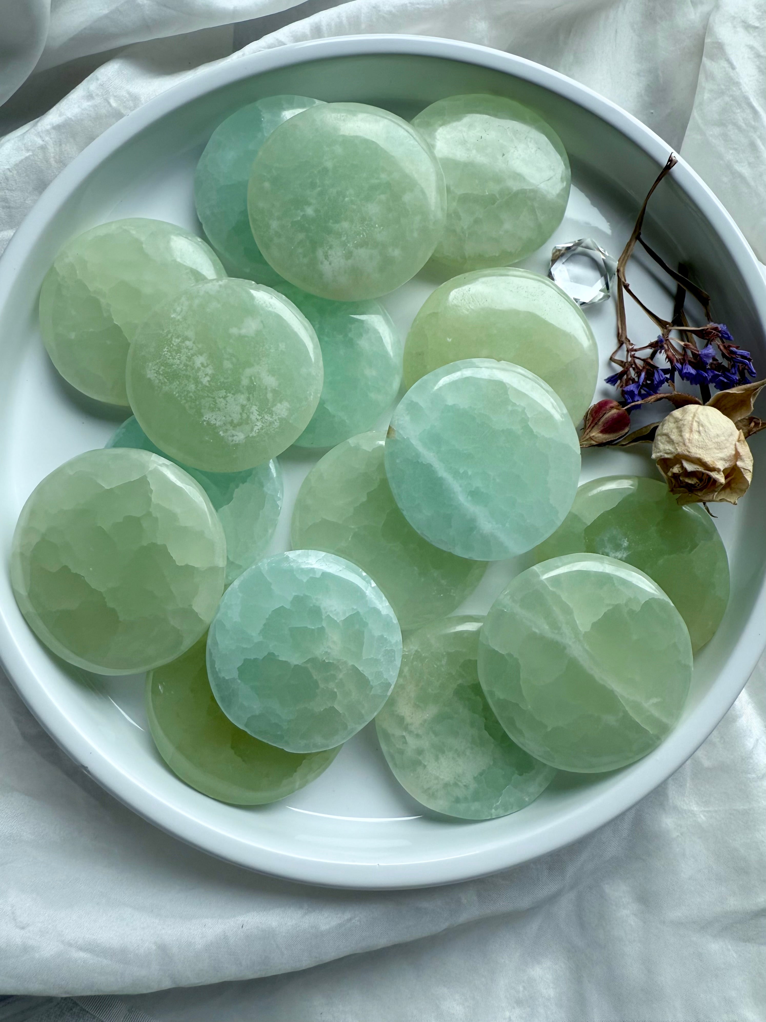 Polished green and aqua Pistachio Calcite palm stones with soft translucent hues – calming stones for clarity, focus, and energy healing work