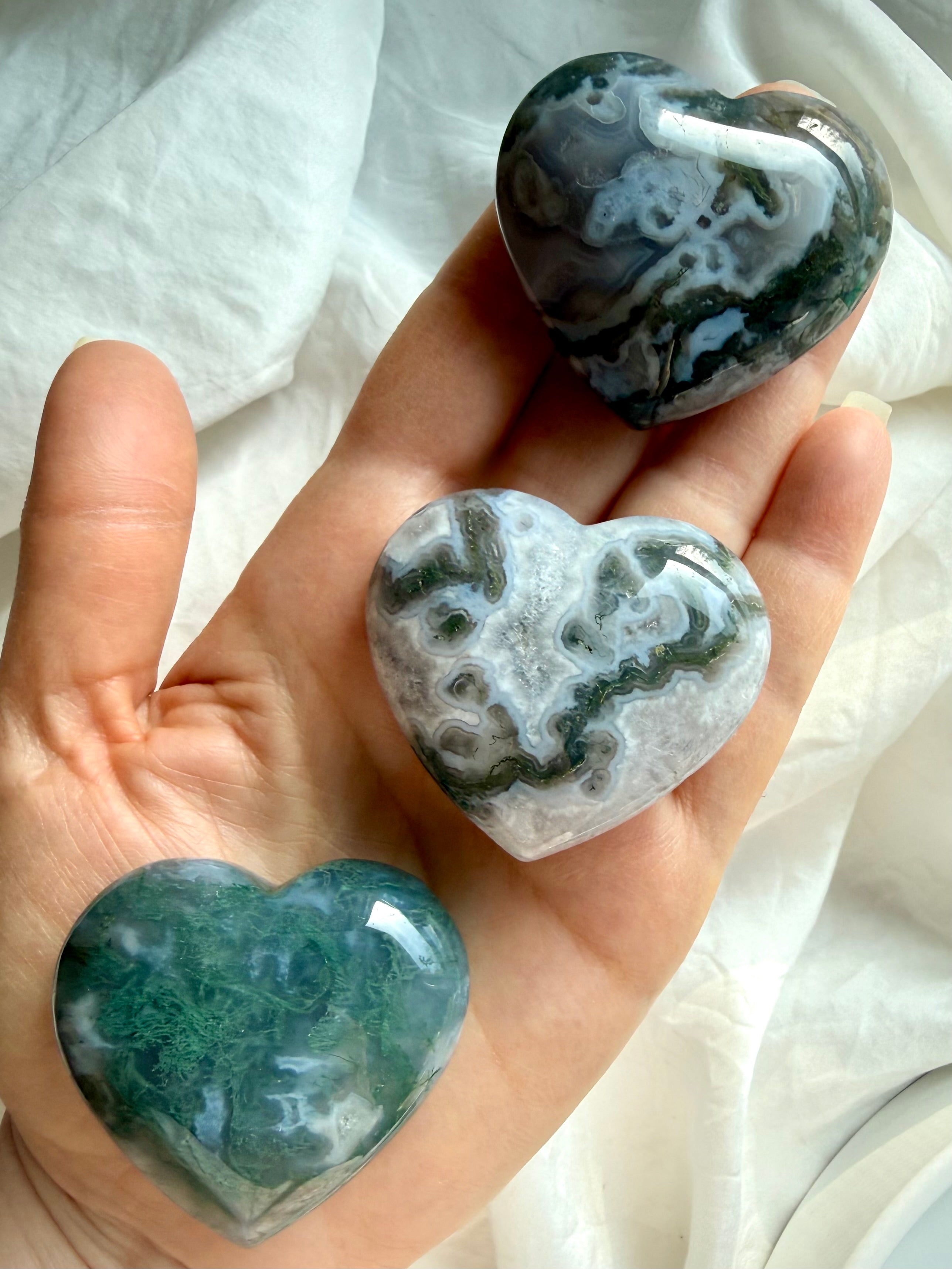 moss agate heart carving held in hand showing mossy green inclusions and natural chalcedony patterns