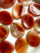 Carnelian Agate worry stones with rich red, orange and golden banded patterns for confidence, creativity and motivation