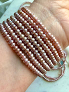 stacked pink freshwater pearl bracelets worn on wrist, elegant pearl bracelet layering for feminine energy and style