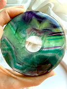 Detail of rainbow fluorite donut crystal showing layered color bands and clarity