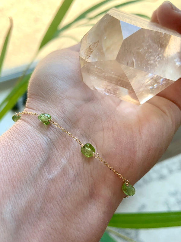 Dainty Peridot gemstone bracelet  shown in gold, on a wrist, also available in sterling silver