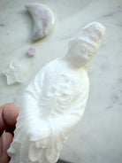 Close-up of White Jade Quan Yin statue showing serene facial features and natural crystalline texture