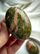 Close up of Unakite palm stone meditation crystal for heart chakra healing, emotional balance & self love