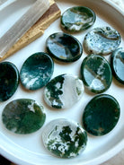 Assorted polished Moss Agate oval worry stones displaying unique green dendritic patterns