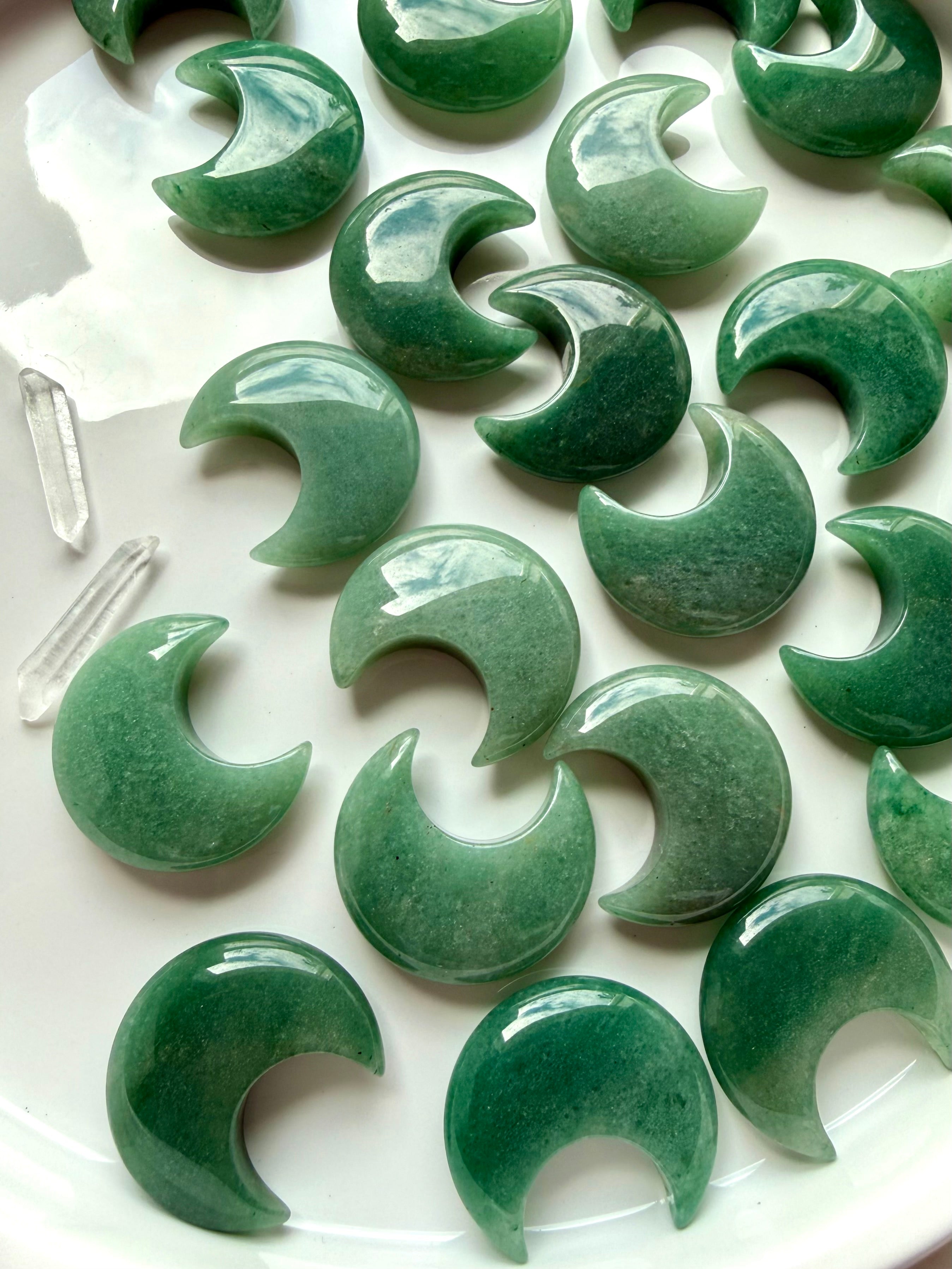 Angled view of Green Aventurine moons on white with quartz points, altar décor for Heart Chakra energy