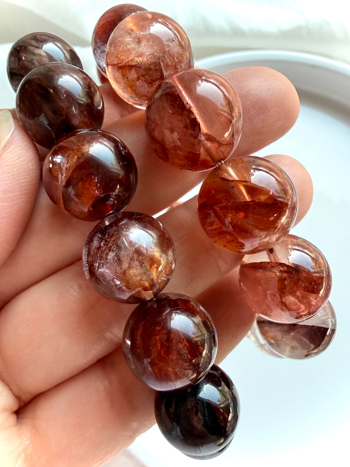 Two Hematoid Quartz bracelets in hand, showing light and dark Fire Quartz styles for comparison