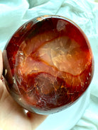 Close-up of fiery orange Carnelian bowl showing inner bands, inclusions, and rich natural color – hand-carved gemstone altar bowl
