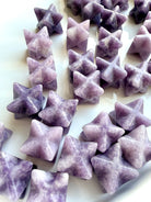 close-up mix of lepidolite merkaba stars showing natural variation in tone and pattern, calming crystals for nervous system support