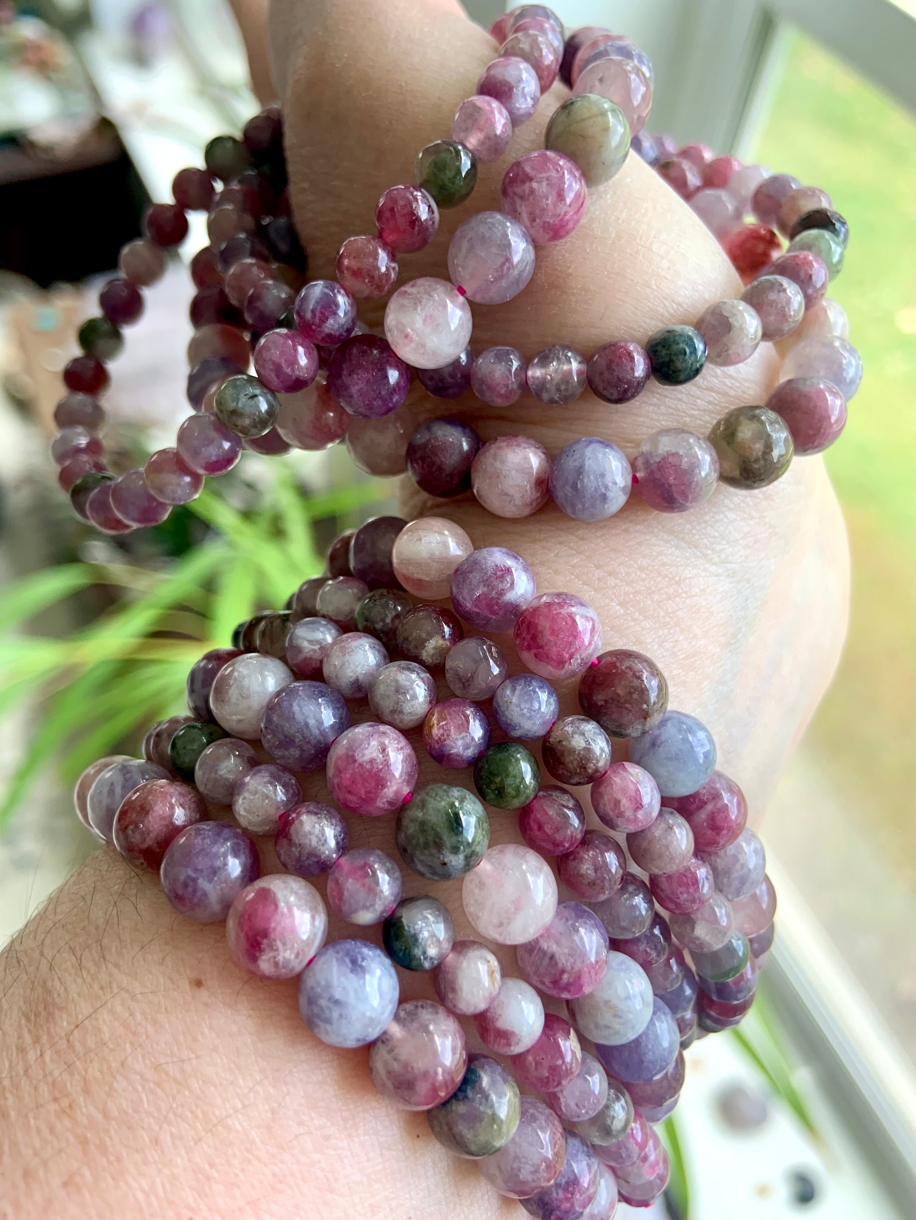 Green Unicorn Stone aka Watermelon Tourmaline & Lepidolite bracelets stacked on wrist and hand — heart chakra crystal bracelets in mixed bead sizes for emotional balance + calm