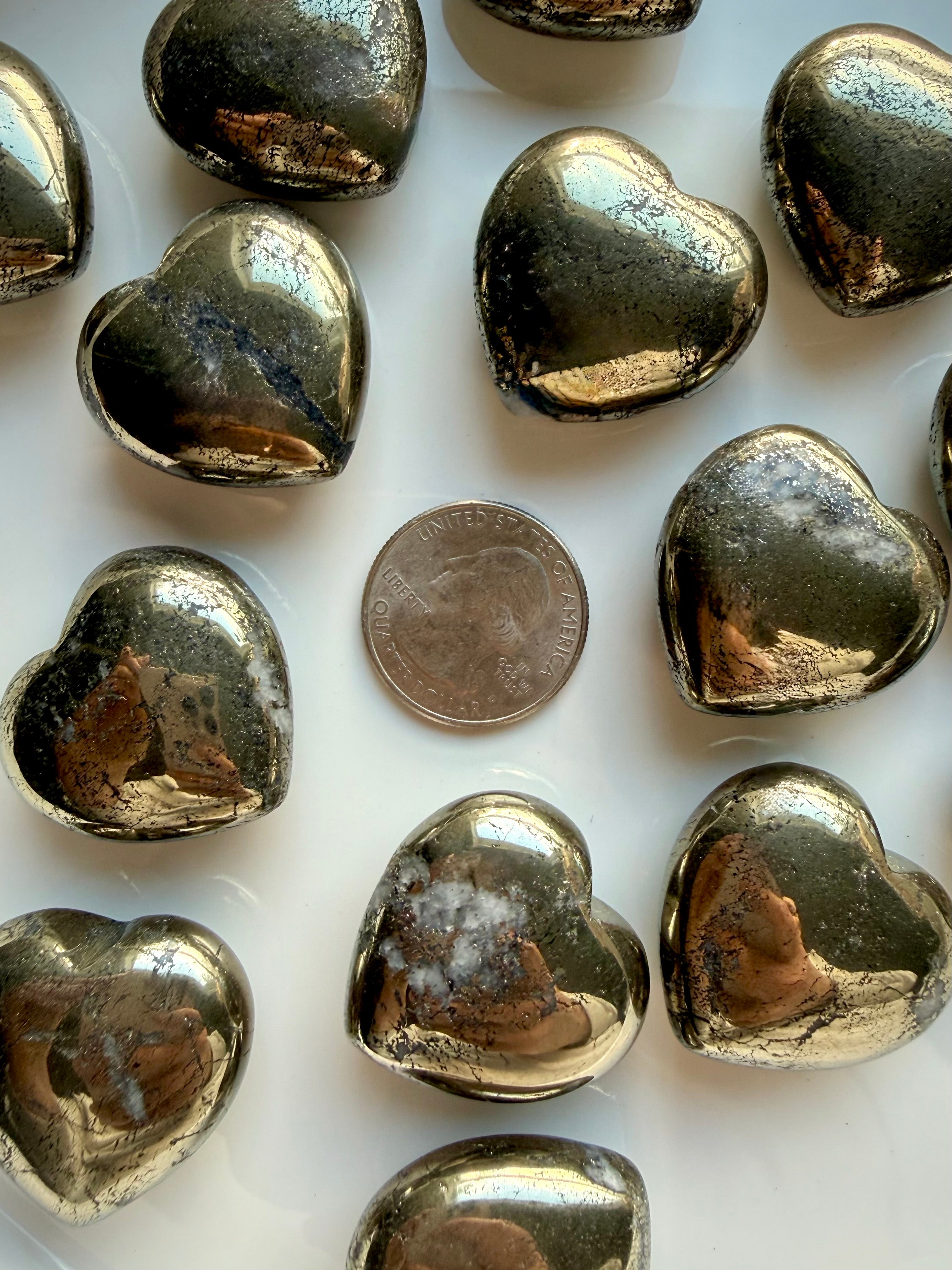 Pyrite heart crystal shown with a U.S. quarter for size reference, polished golden stone for confidence and abundance