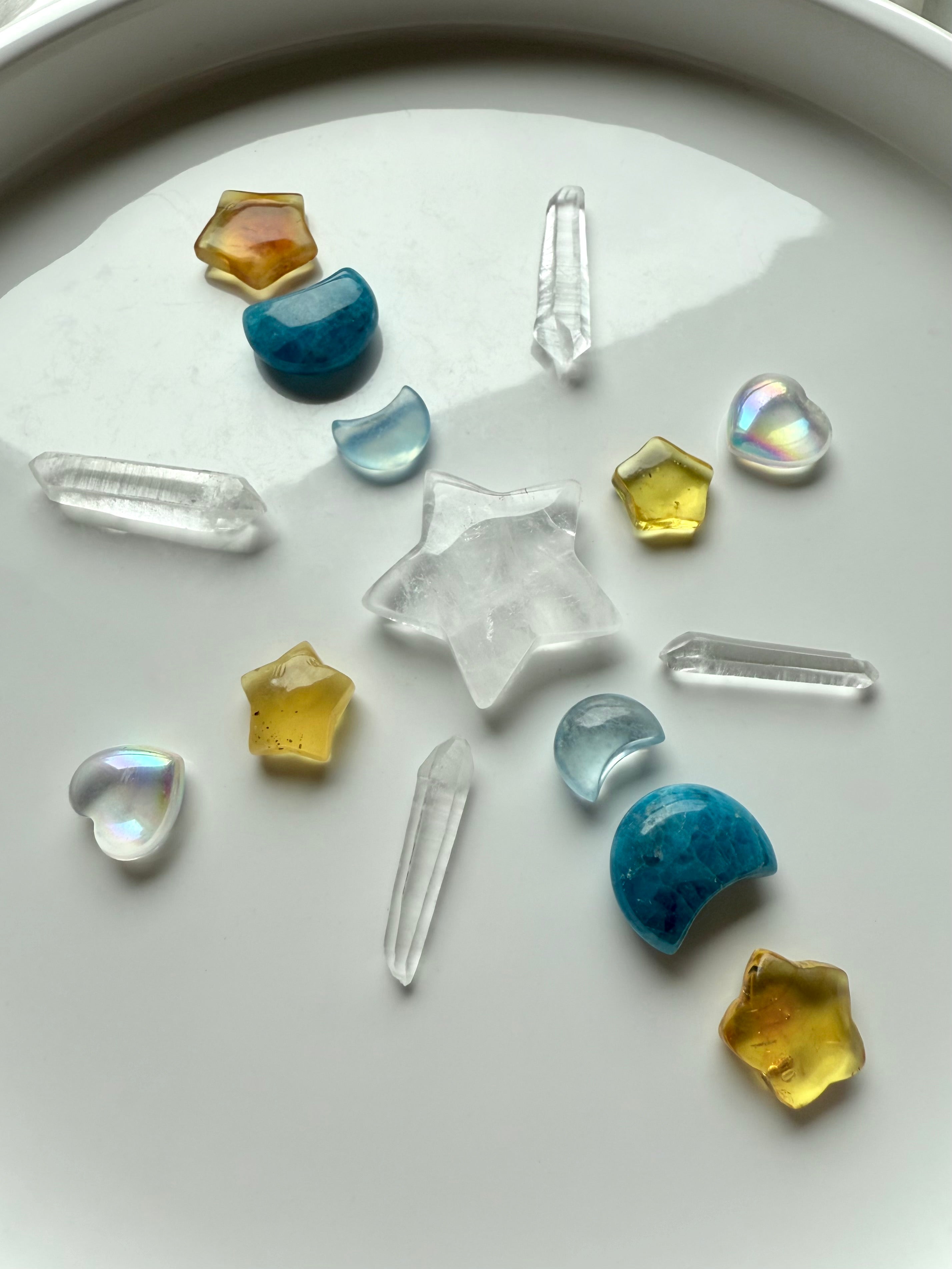 A crystal grid with Mini aura quartz hearts, blue apatite moons, amber stars, and Lemurian points for angelic energy and light