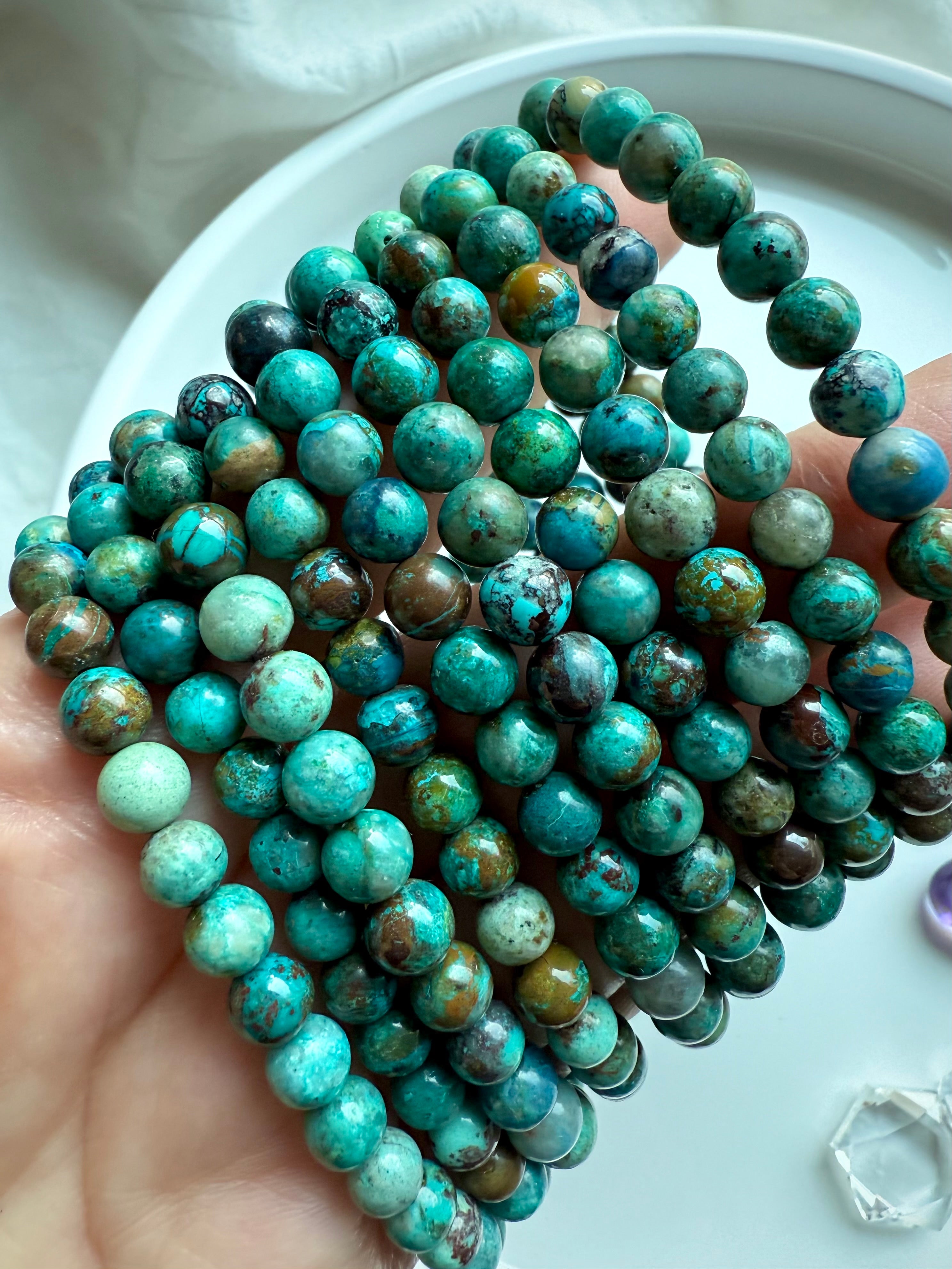 Earthy Chrysocolla Shattuckite gemstone bracelets displayed in hand, crystal healing jewelry for empowerment and expression