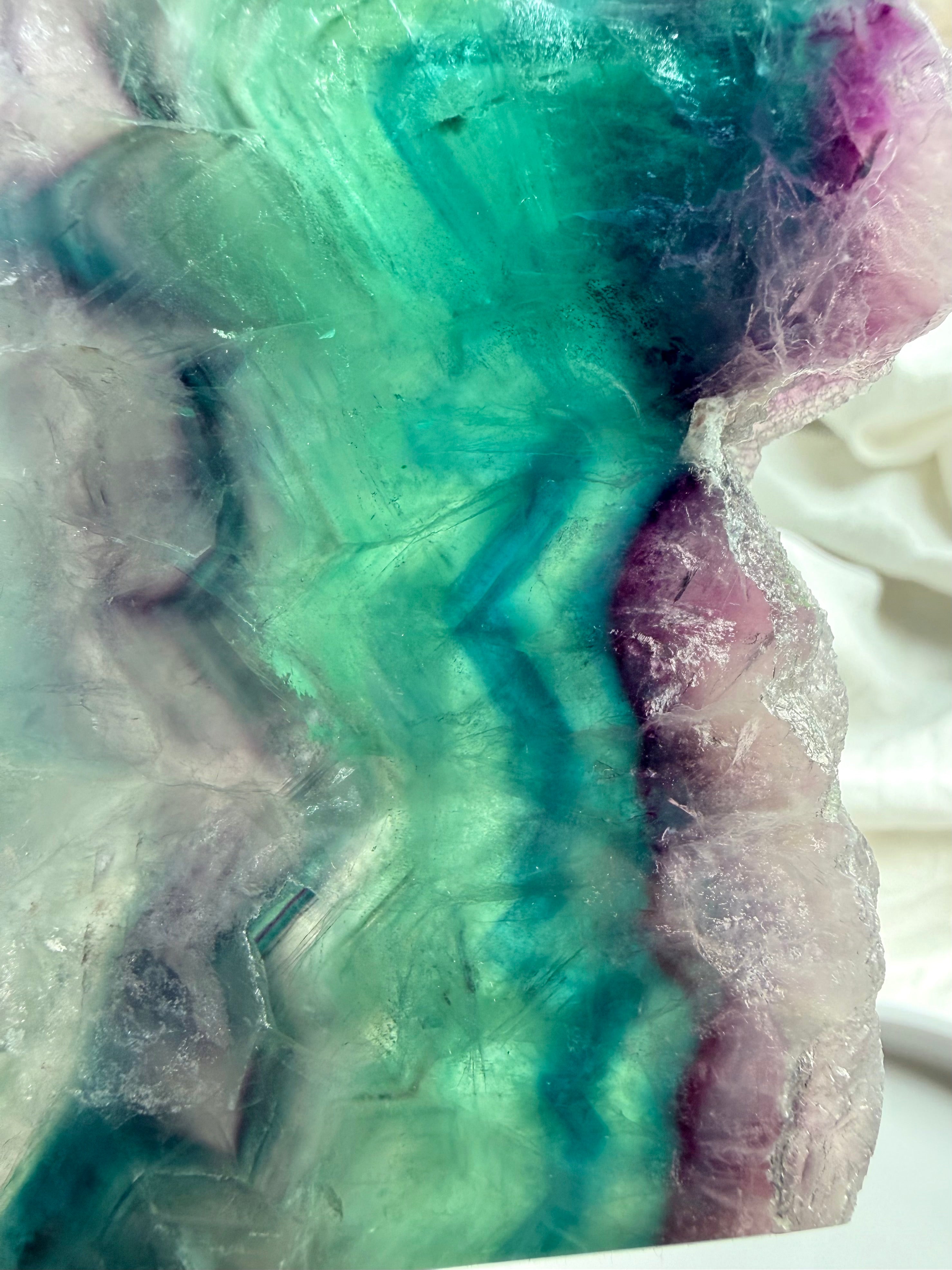Close-up of natural fluorite slab showing layered color zoning and polished crystal surface