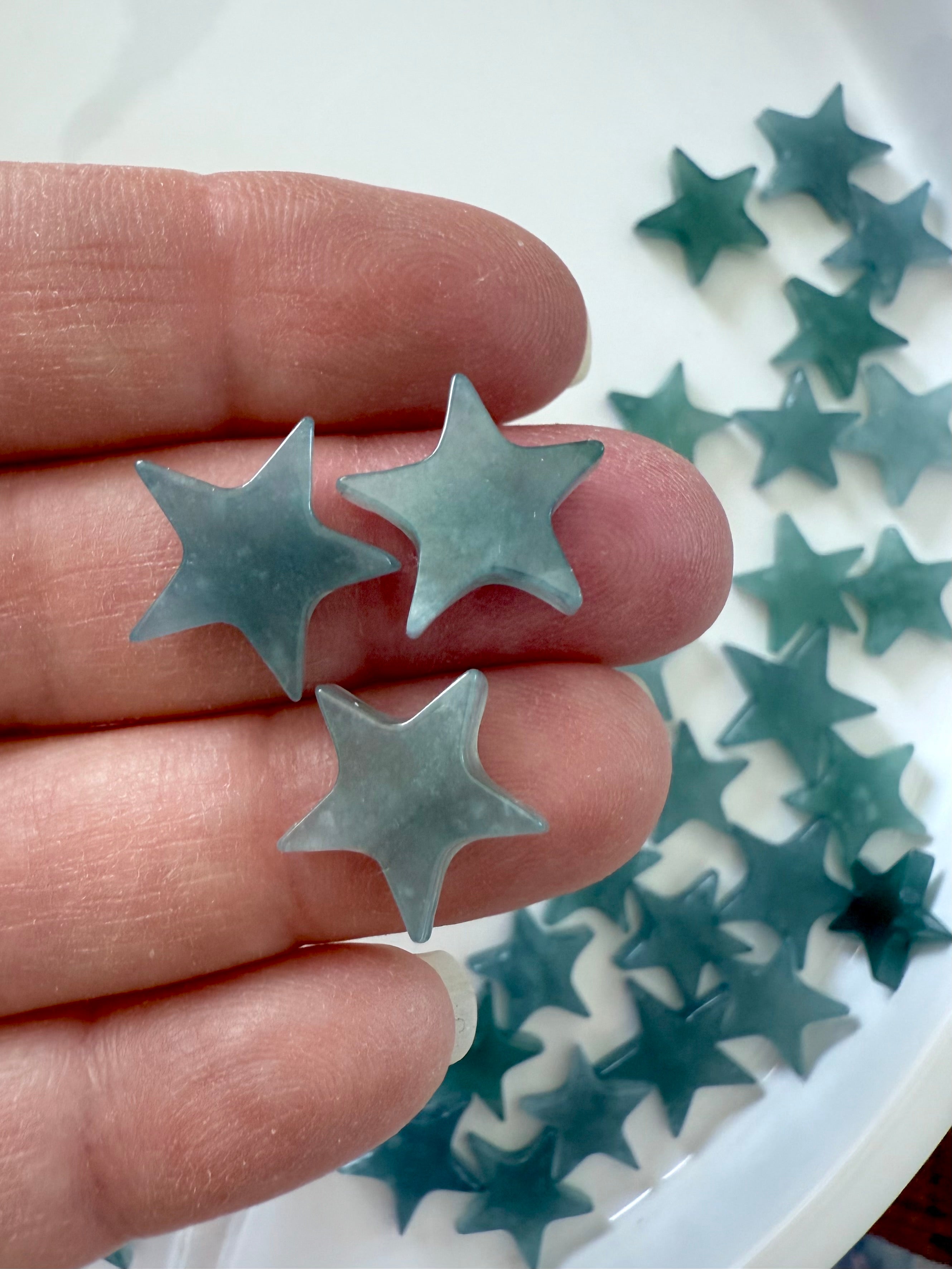 Close up of our Mini Blue Water Jade Stars shown on my hand for scale