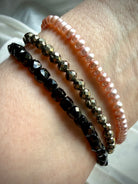 pyrite bracelet stacked with black spinel and pink pearl bracelets for protection grounding and feminine balance
