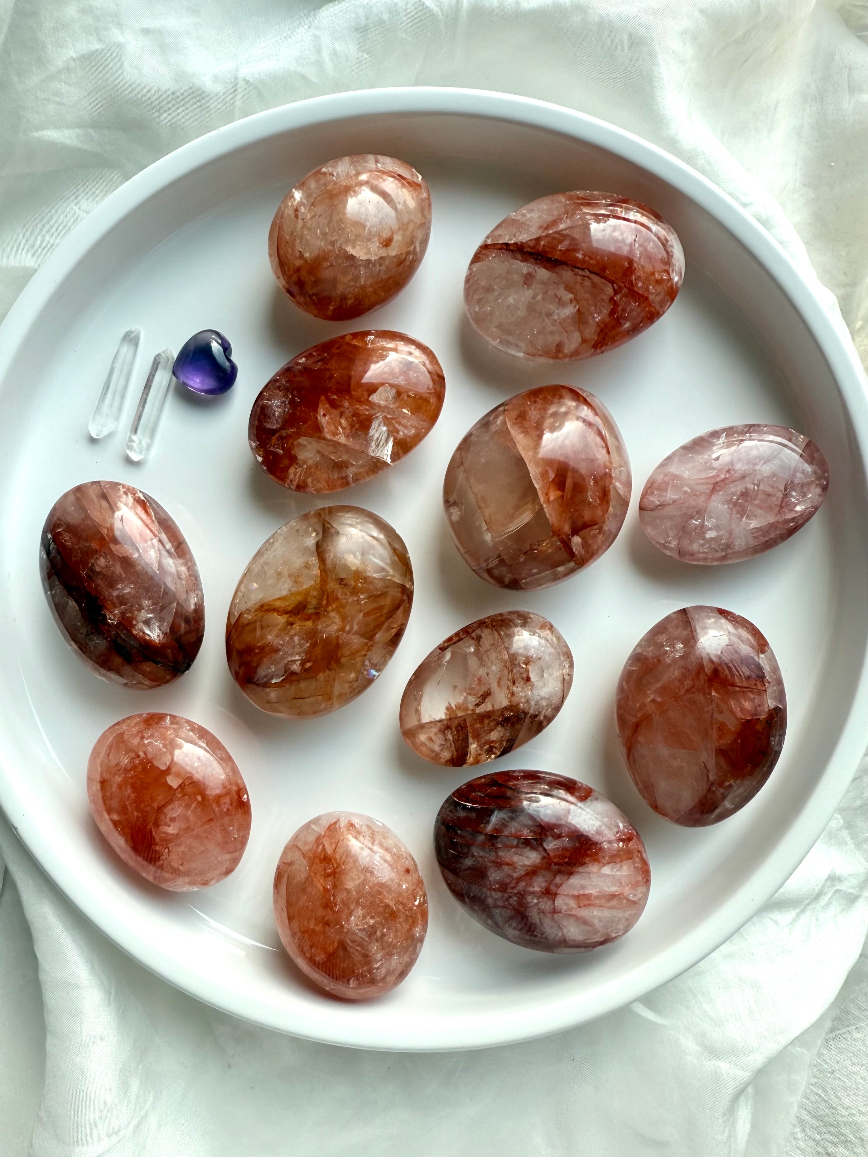 Group of Fire Quartz palm stones with natural variations in hematite inclusions and quartz clarity