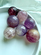 Silky Magenta Fluorite spheres in pastel pink and purple tones with natural banding for intuition and emotional healing