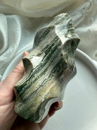 Textured Green Ocean Jasper bands with soft sage, cream, and forest-green hues in a hand-carved flame shaped crystal.