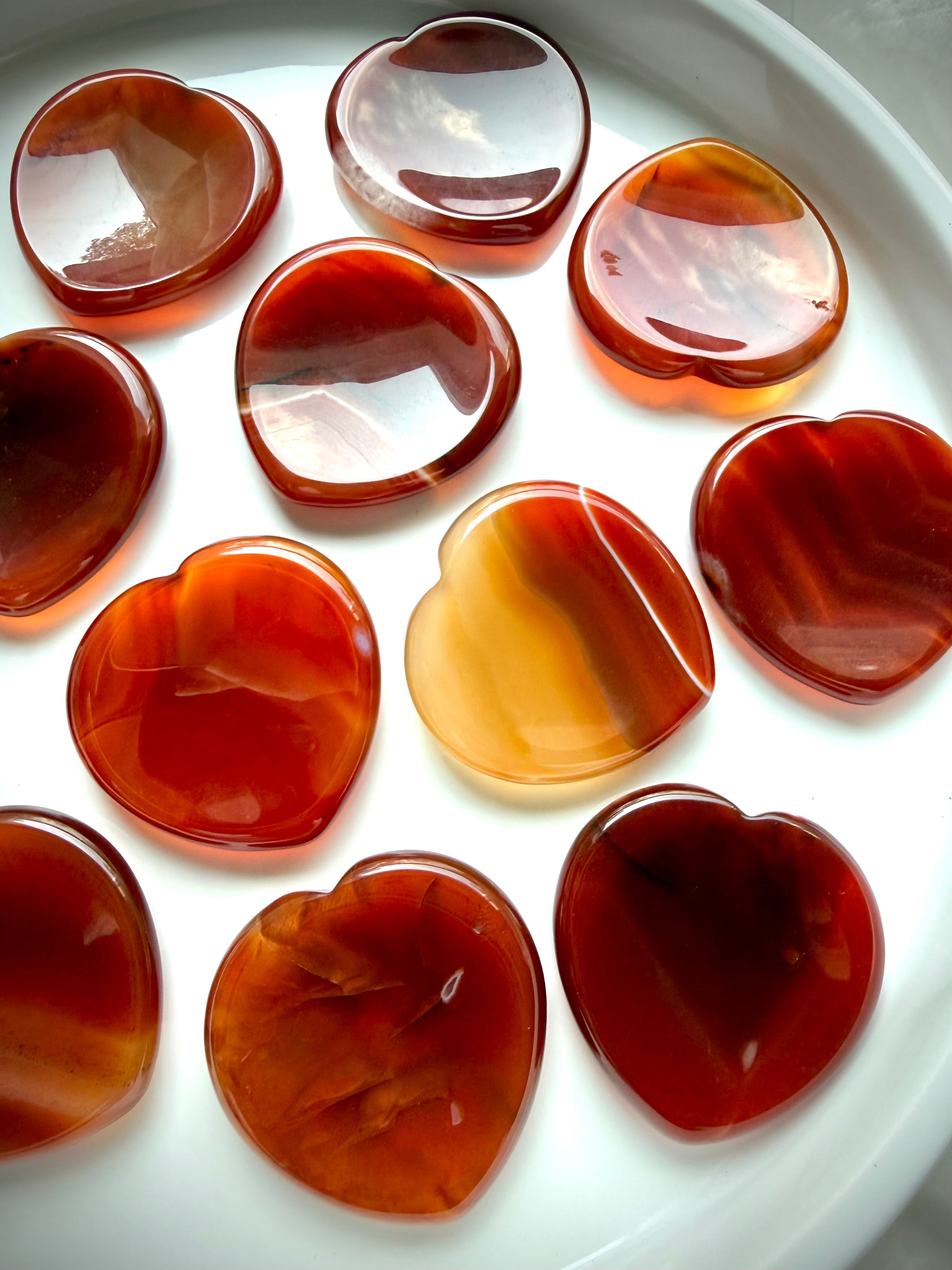 Carnelian heart worry stones with translucent red-orange tones and natural banding for confidence and Sacral Chakra healing