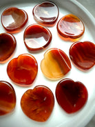 Carnelian heart worry stones with translucent red-orange tones and natural banding for confidence and Sacral Chakra healing