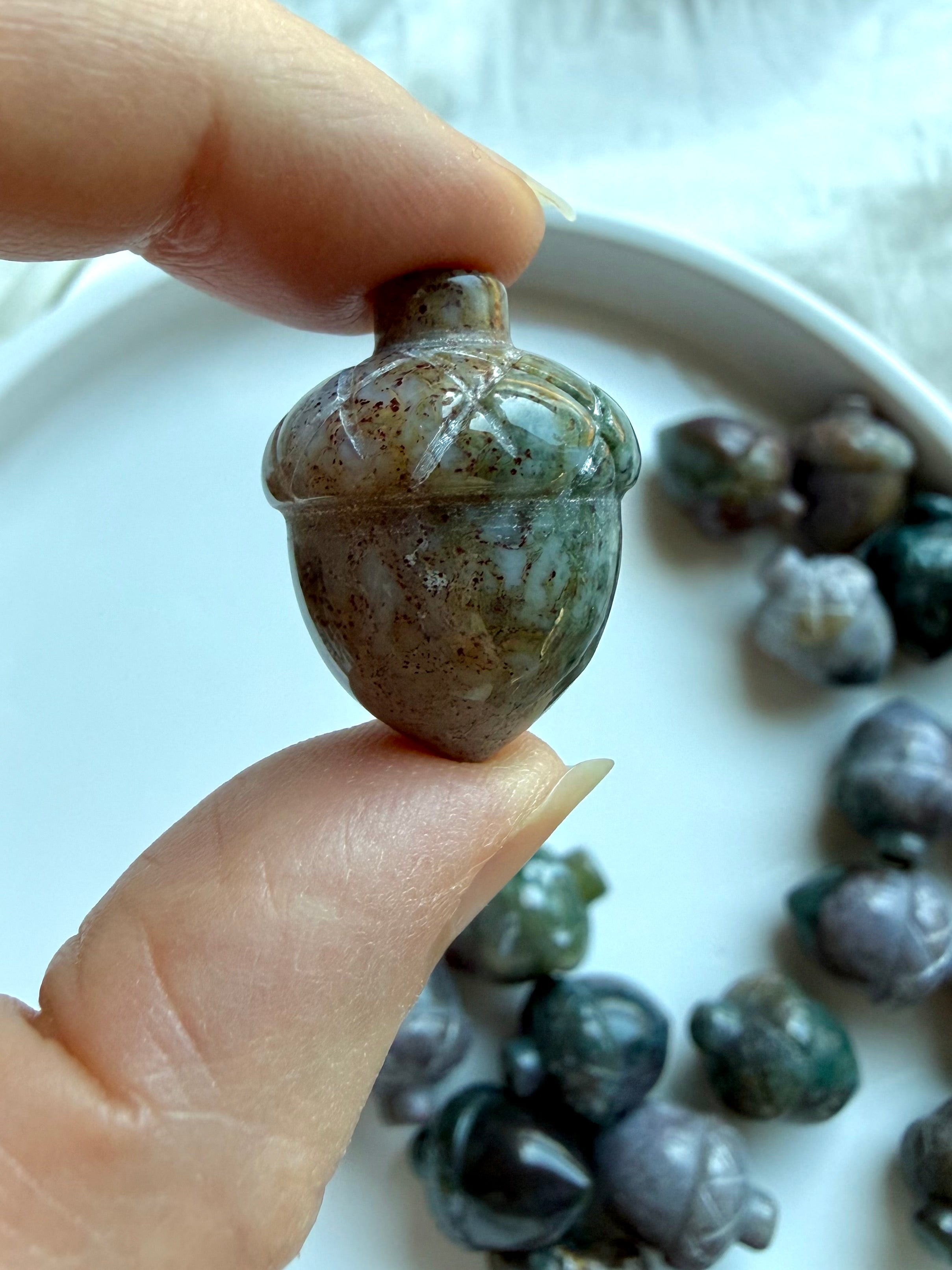 Teal Ocean Jasper acorn carving held in hand showing natural speckles, earthy color zoning and carved acorn cap