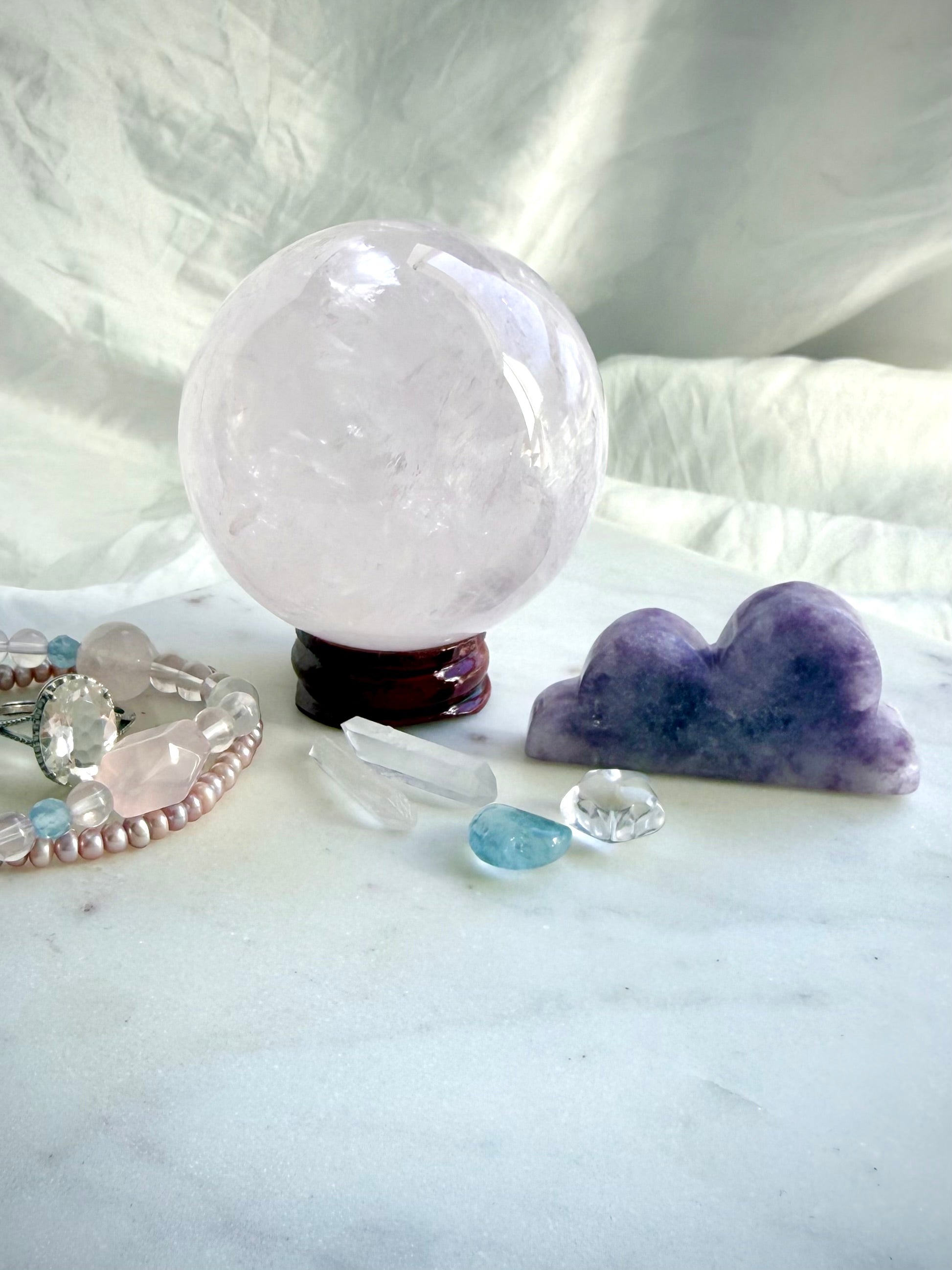 Lepidolite cloud carving displayed with Rose Quartz sphere and crystals for peaceful altar decor