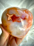 Carnelian heart crystal displaying rich sunset orange banding and natural heart-shaped patterns in polished finish