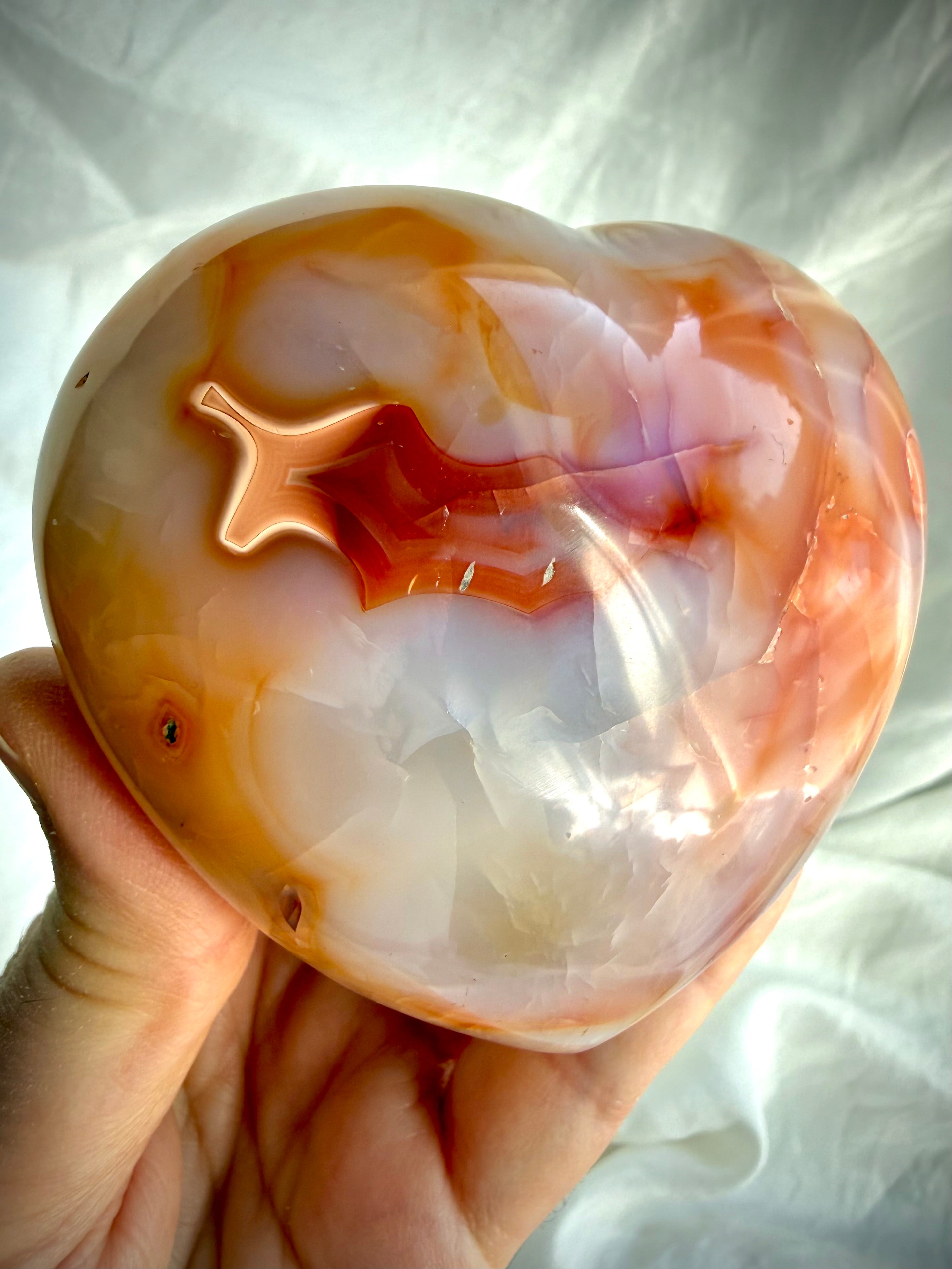 Carnelian heart crystal displaying rich sunset orange banding and natural heart-shaped patterns in polished finish