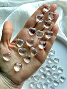 Mini Clear Quartz heart crystal held in hand showing transparent quartz and puffy heart shape