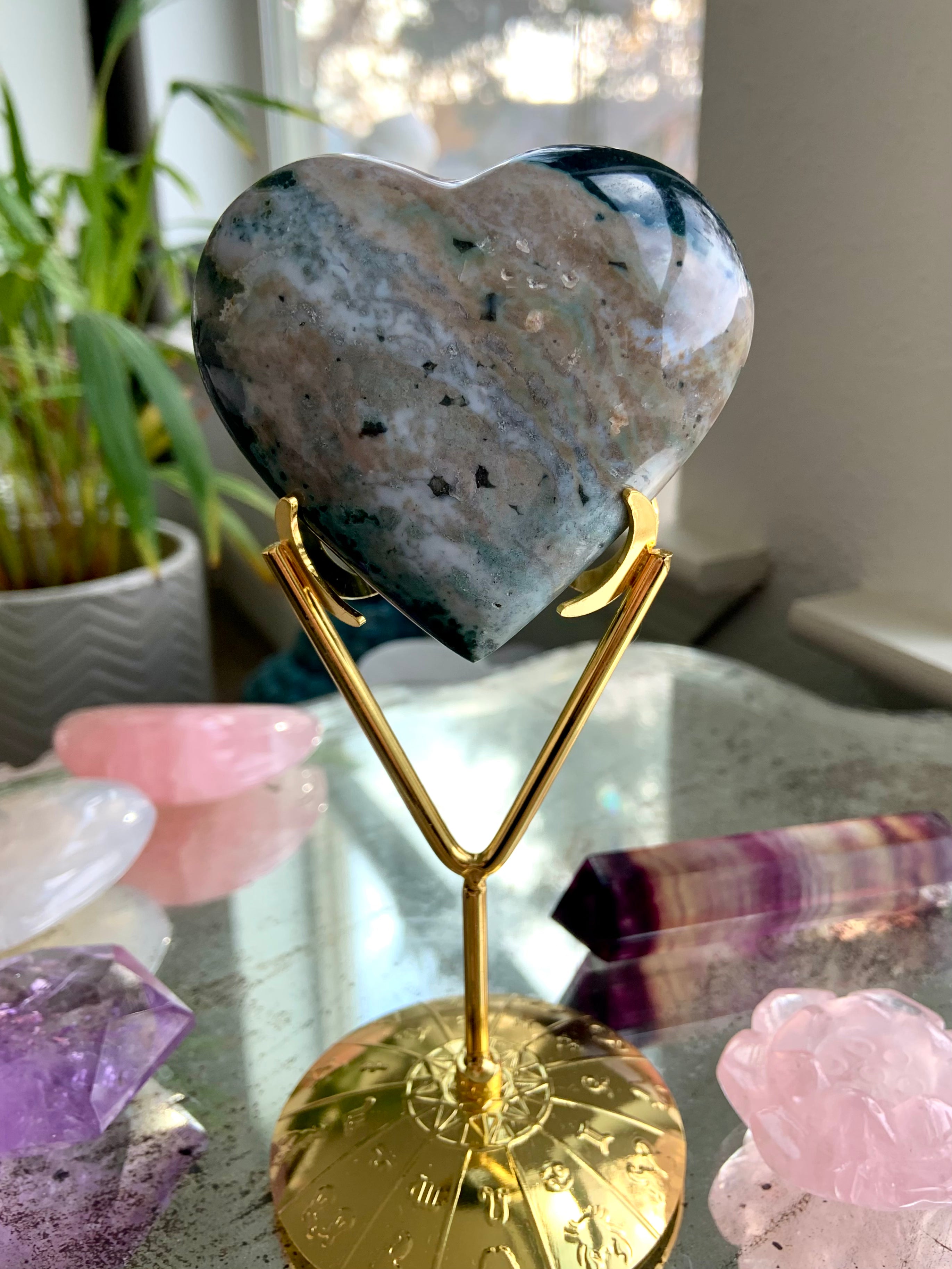 Crystal display stand holding an Ocean Jasper heart — elegant gold crystal holder for showcasing carvings & crystal decor.