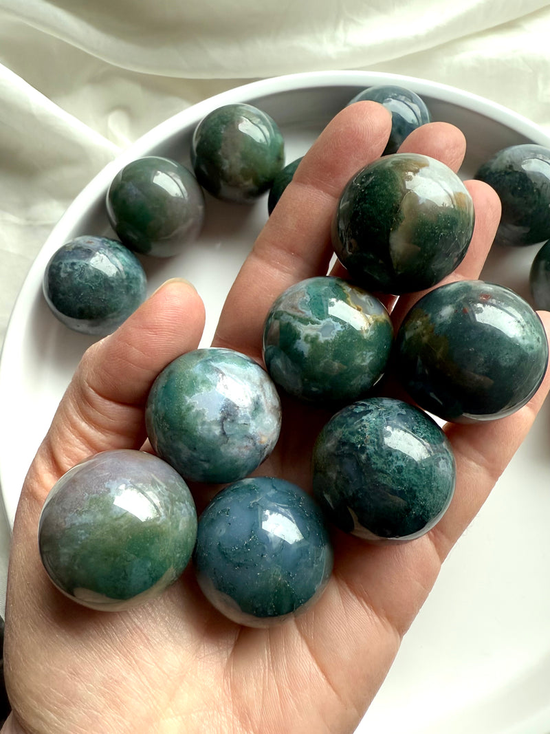 Colorful moss agate mini spheres shown on my hand