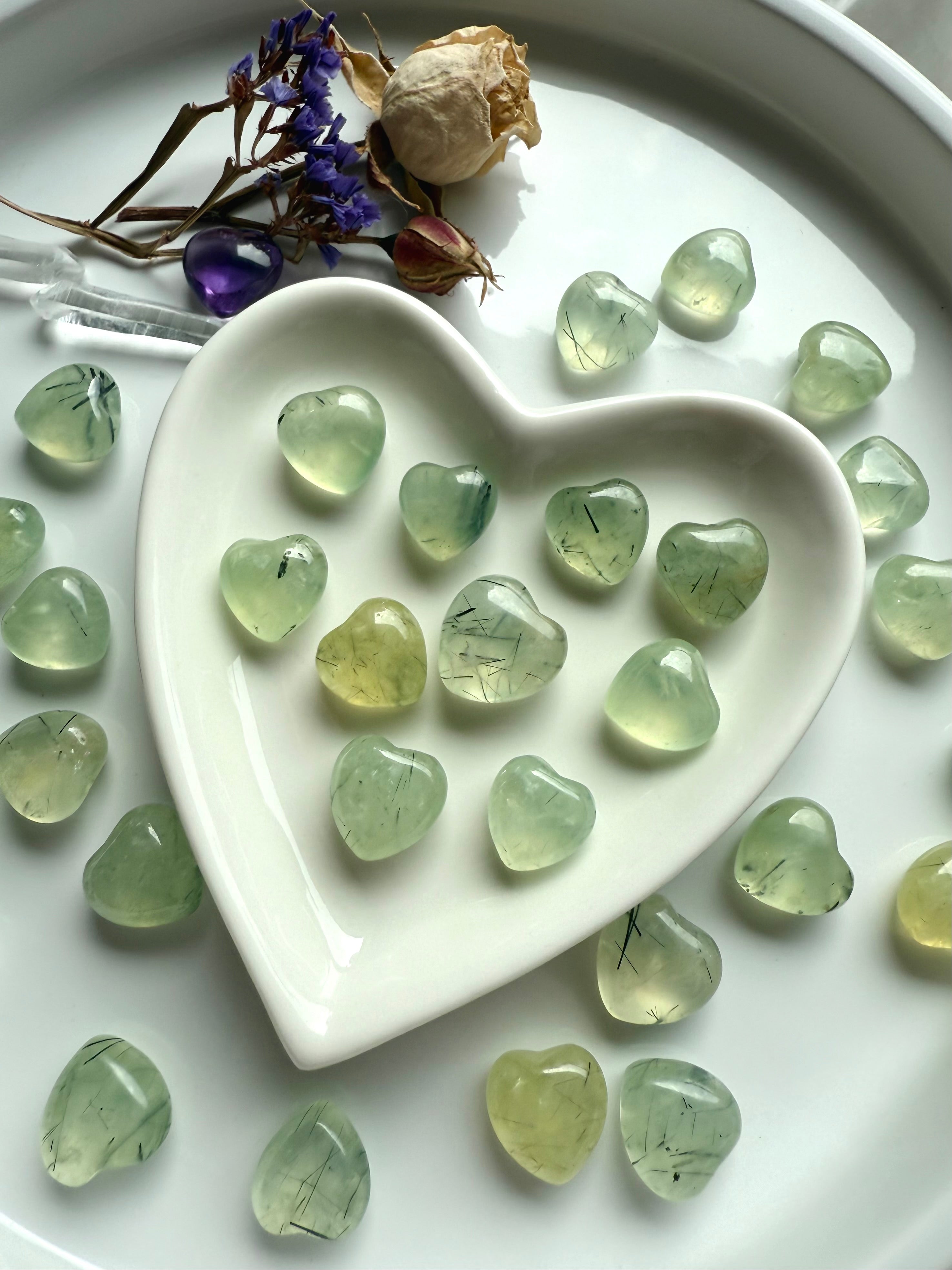 Mini Prehnite with Epidote gemstone hearts polished for smooth texture, displayed in white ceramic heart bowl.