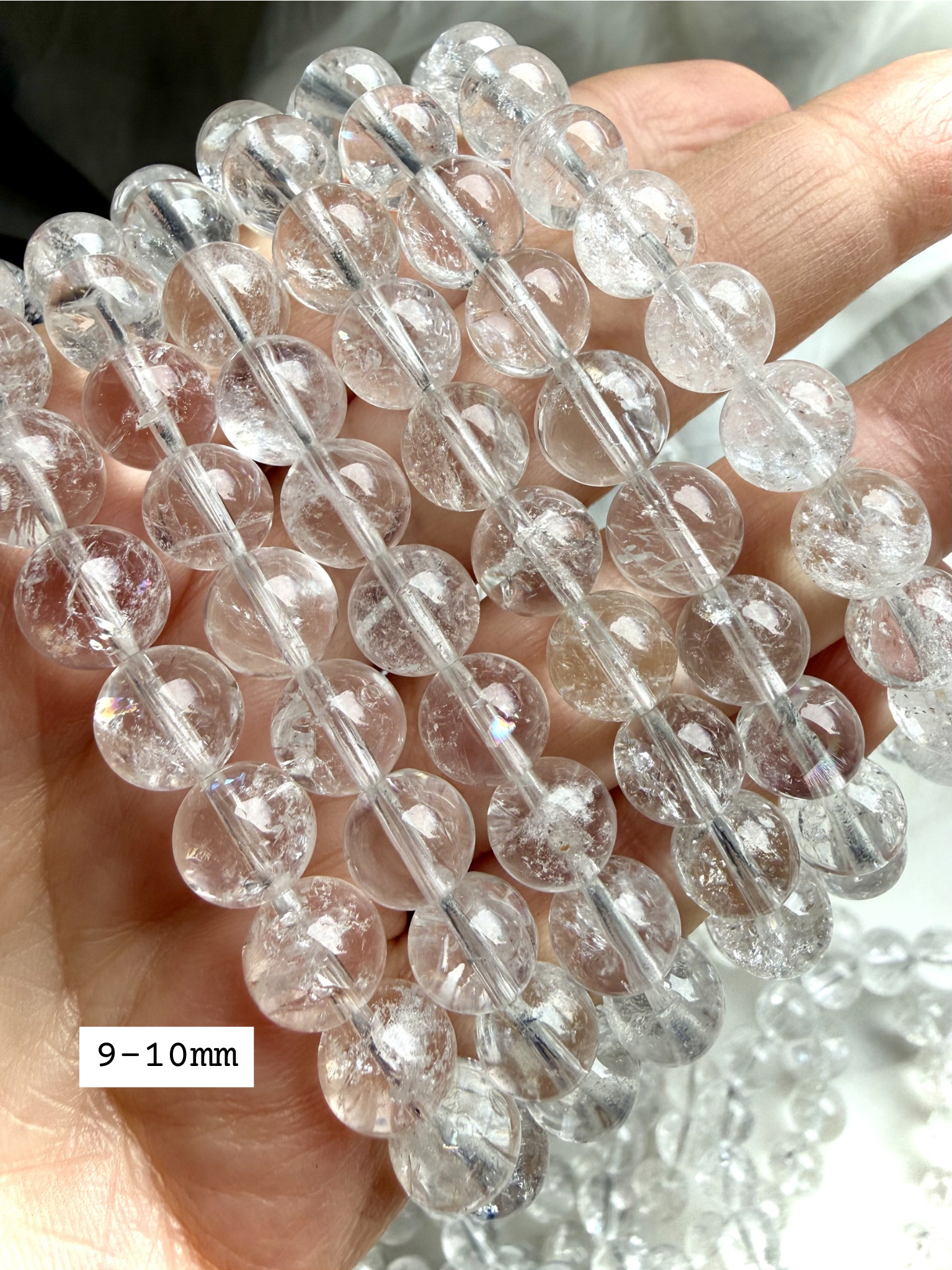 Polished Rainbow Clear Quartz crystal bracelets showing 9-10mm transparent gemstone beads in natural sunlight