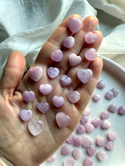 Handful of Mini Kunzite Hearts showing size and color variation – pink and lavender kunzite for emotional healing and heart chakra support